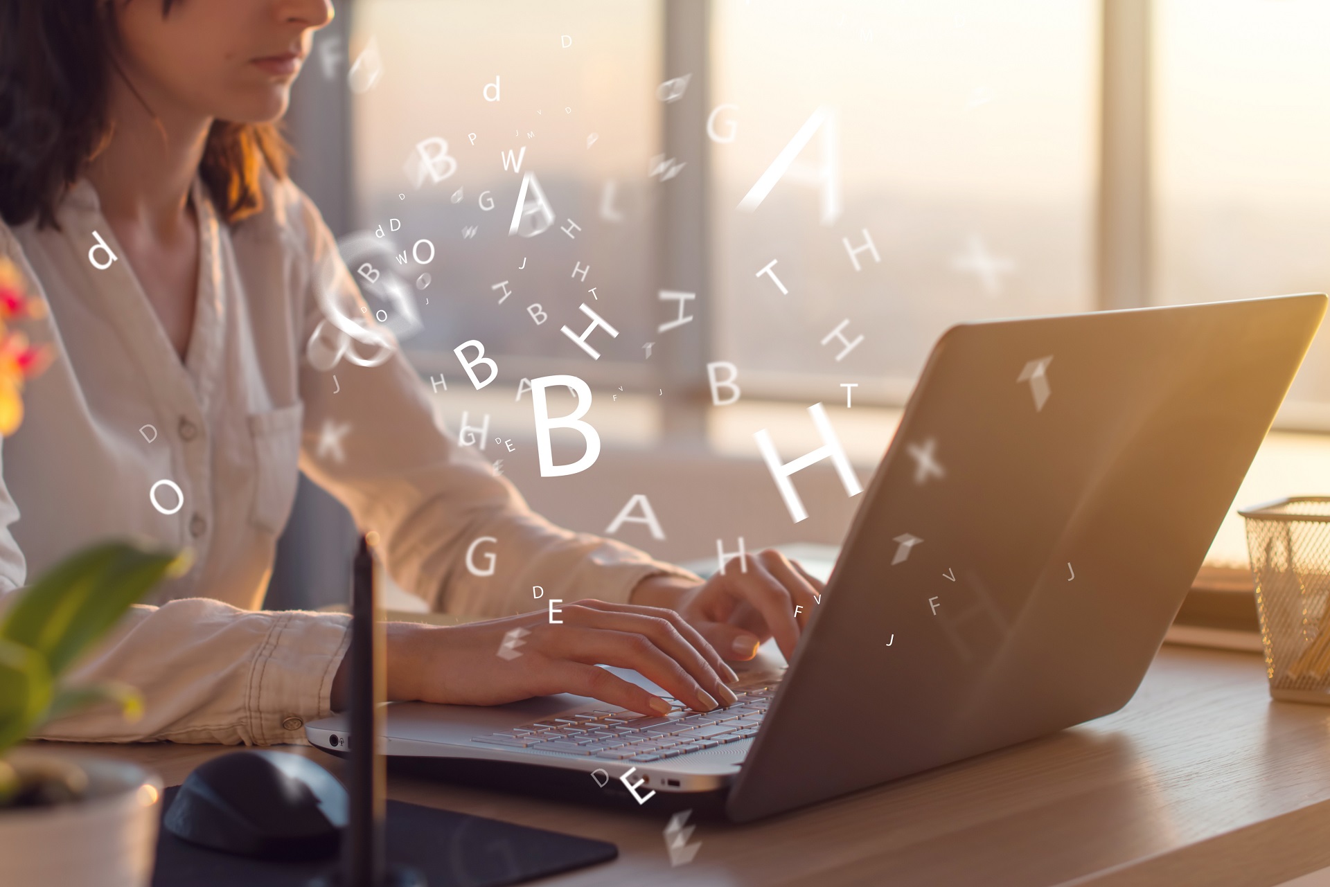 Webdesigner/Entwickler arbeitet an einem Laptop mit umherschwirrenden Buchstaben.